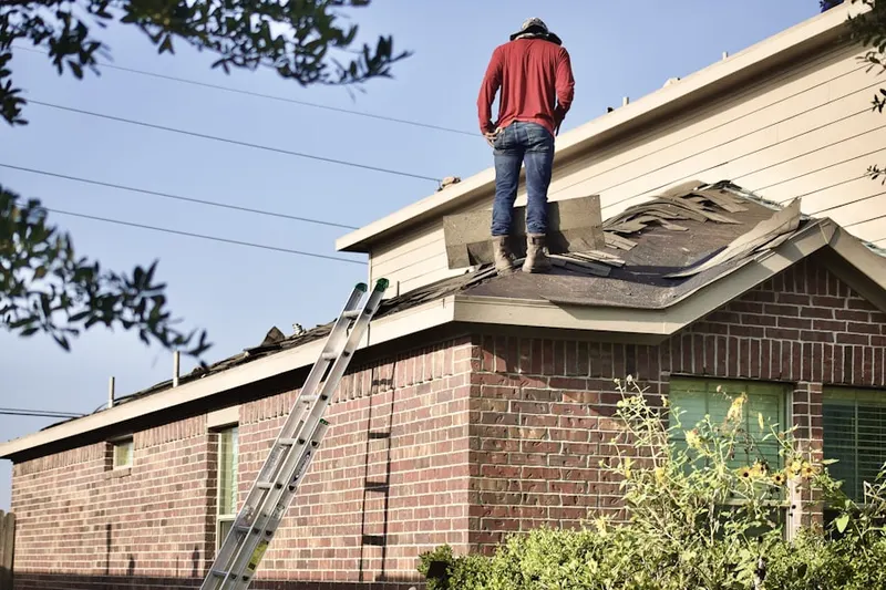 Professional roofer working on a residential roof in Okmulgee